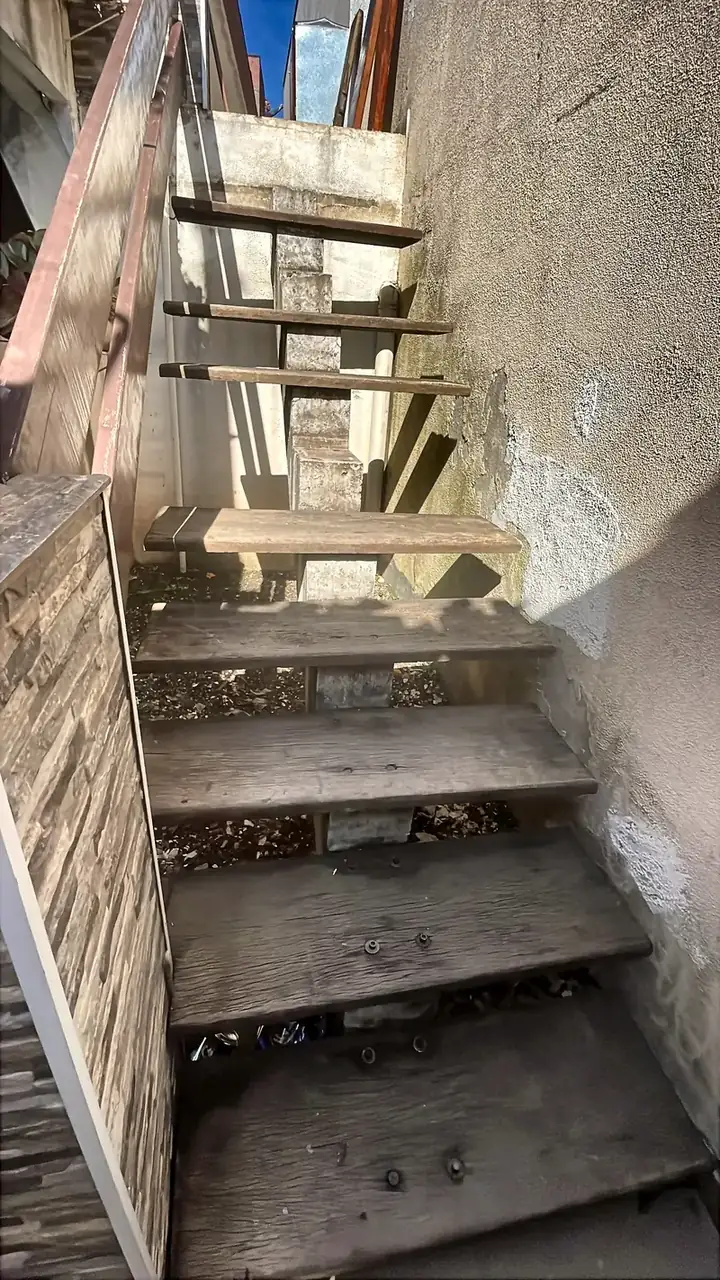 Escada externa antes da reforma, com degraus de madeira desgastados