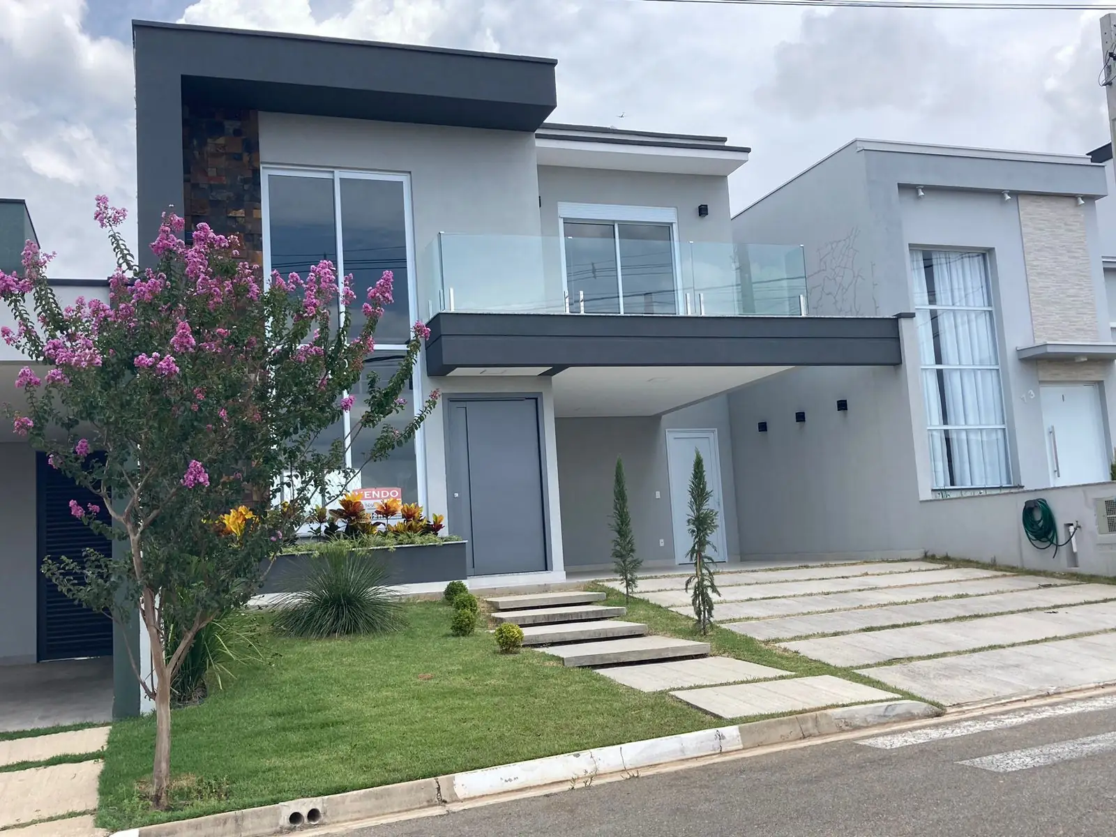 Fachada de sobrado moderno com sacada de vidro, construído pela Sousa Mendes